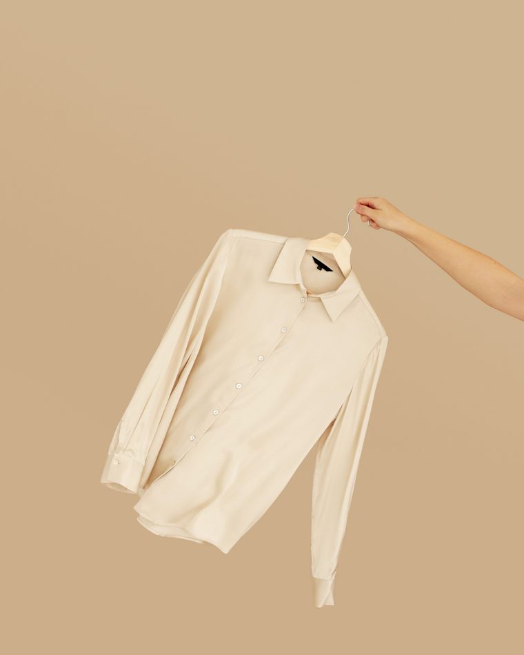 Minimalist beige shirt on a hanger